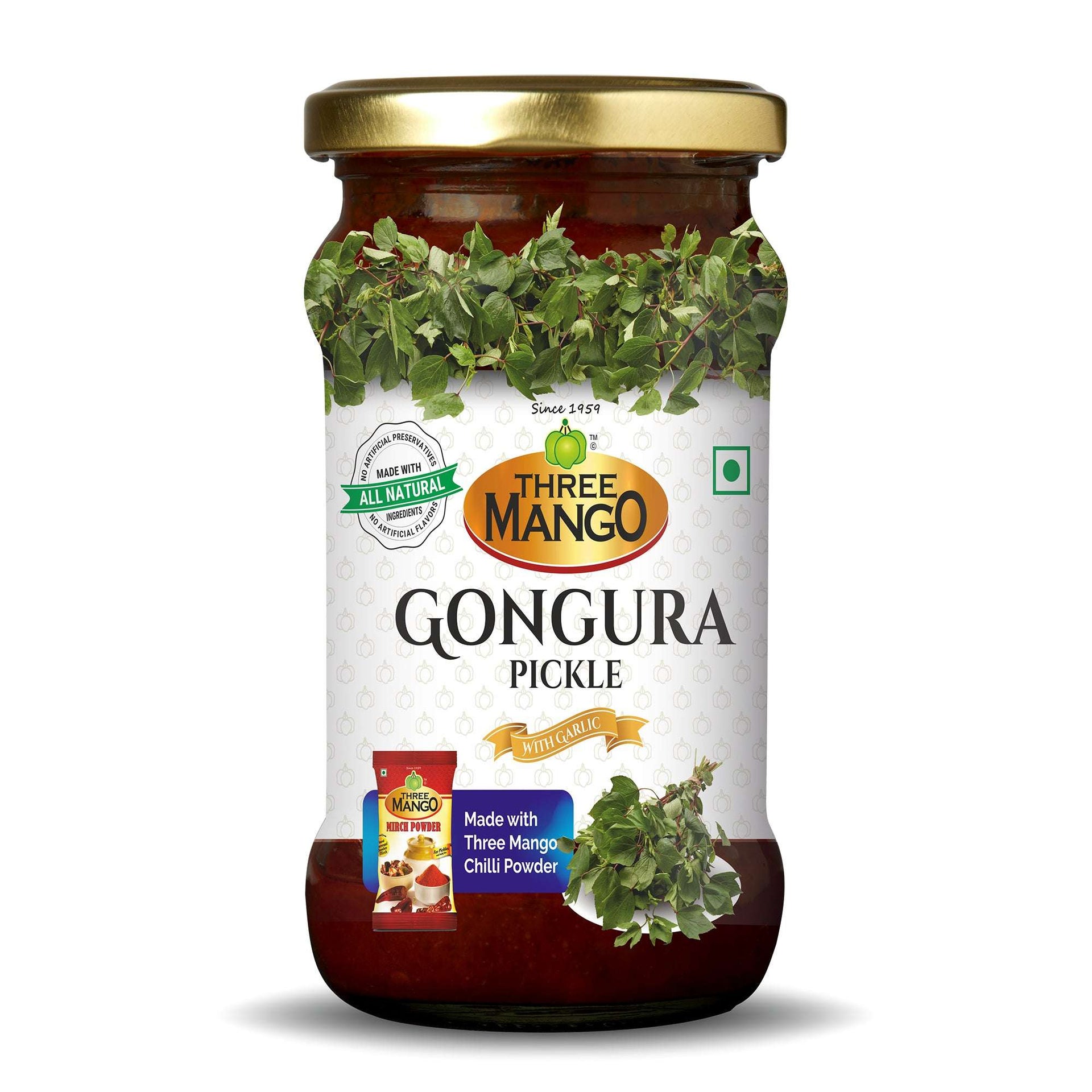 Three Mango Gongura Pickle jar with garlic, labeled all natural and made with Three Mango chili powder, featuring images of fresh gongura leaves on white and red packaging.