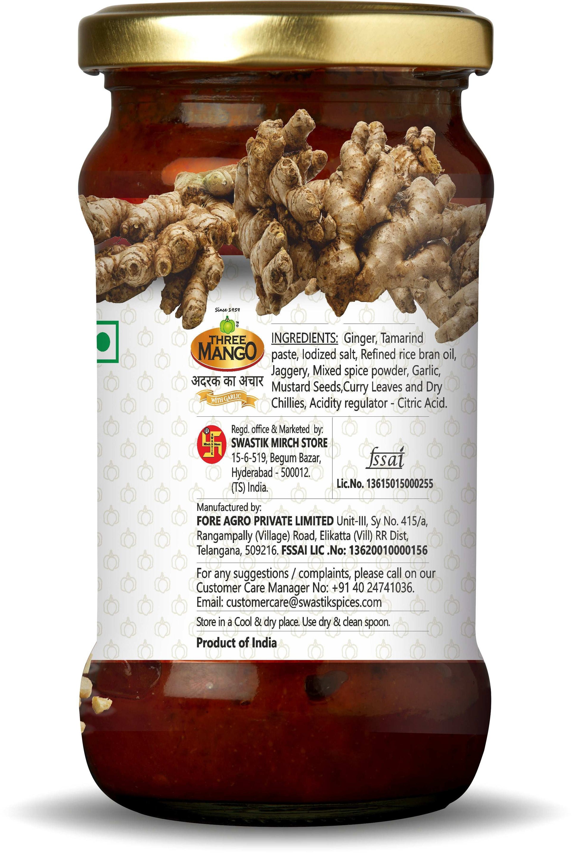 Back view of Three Mango Ginger Pickle jar displaying ingredients list, manufacturer details, FSSAI licenses, and contact information on white label with ginger graphics.