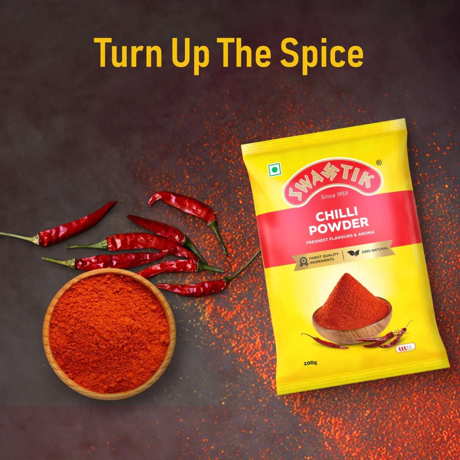 Swastik Chilli Powder 100g pack with dried red chillies and a bowl of chilli powder, placed on a dark surface with the caption “Turn Up The Spice” highlighting its bold heat.