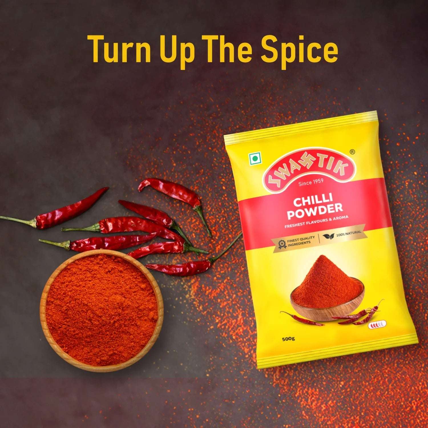 Swastik Chilli Powder 500g pack with dried red chillies and a bowl of chilli powder, placed on a dark surface with the caption “Turn Up The Spice” highlighting its bold heat.