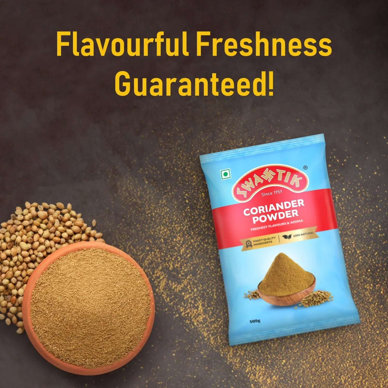 Swastik Coriander Powder 500g pack placed beside a terracotta bowl of ground coriander and coriander seeds on a dark background with the tagline 'Flavourful Freshness Guaranteed'