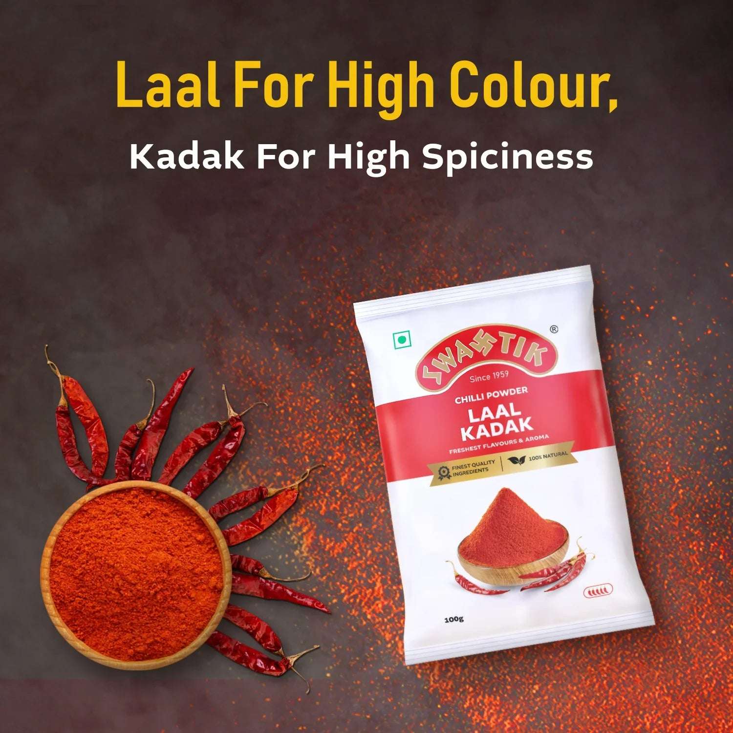Swastik Laal Kadak Chilli Powder 100g pack placed beside a bowl of red chilli powder and whole chillies arranged like sun rays, with caption highlighting colour and spiciness.